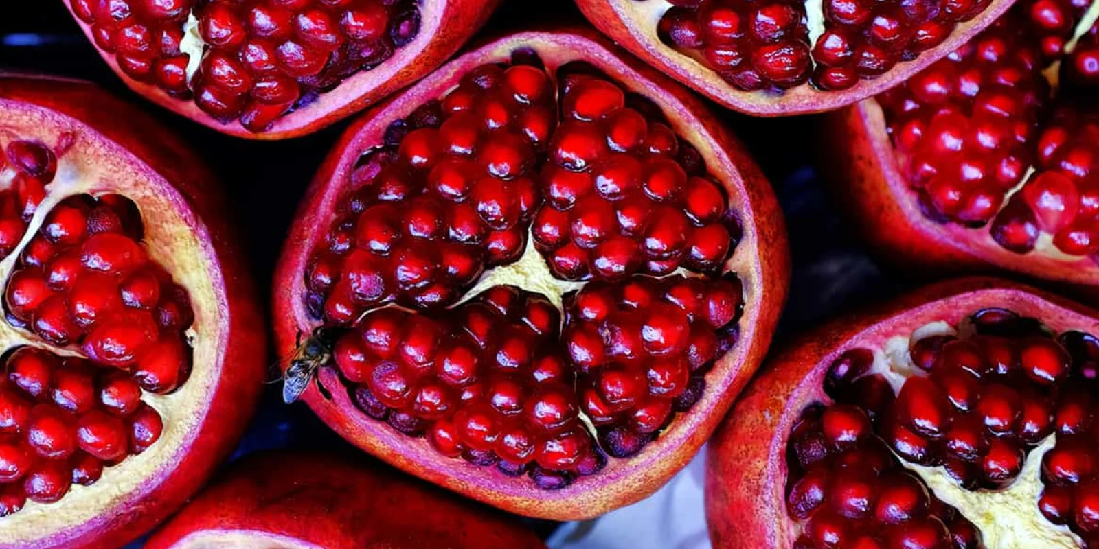 Some in season pomegranates open to show the seeds